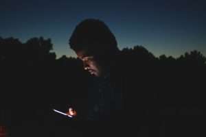 Man using a phone in the dark.